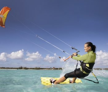 An athletic woman kite boarding in the Caribbean.